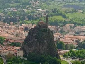 una formación rocosa con un edificio encima en La maison des roses en Chadrac