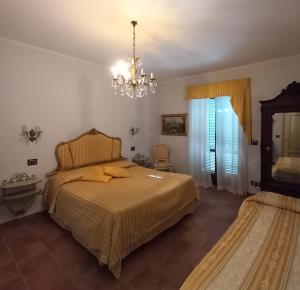 um quarto com uma cama e um lustre em Agriturismo Brusalino em Mango