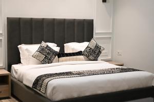 a bedroom with a large bed with black and white pillows at Elegance Regency in Khanna