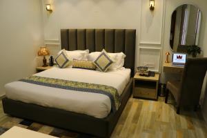 a bedroom with a large bed and a chair at Elegance Regency in Khanna