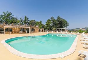 a large swimming pool with chairs and a building at Villa Serra Alta in Fermignano