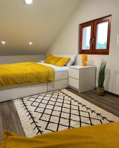 a bedroom with two beds with yellow pillows and a rug at Mila Vila, Fruška Gora in Irig