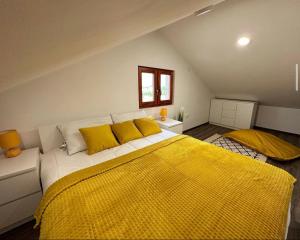 um quarto com uma grande cama amarela com almofadas amarelas em Mila Vila, Fruška Gora em Irig