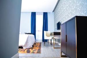 una camera d'albergo con letto e scrivania di Djeuga Palace Hotel a Yaoundé
