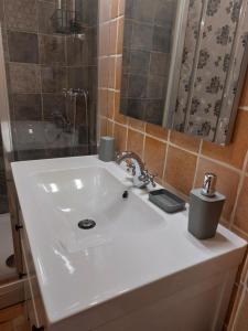a bathroom with a white sink and a shower at APARTMENT KORTINE in Sečovlje