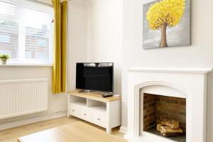 a living room with a tv and a fireplace at Bristol House FREE Parking & Airport & M1 & Contractor in Luton