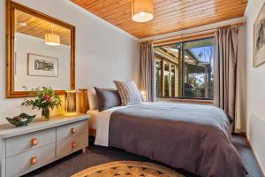 um quarto com uma cama e uma janela em Mandala Bruny Island em Alonnah