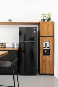 einen schwarzen Kühlschrank in einer Küche neben einer Theke in der Unterkunft The R Villa Kaba - incl. Motorbikes in Seminyak