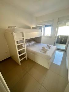 Mały pokój z 2 łóżkami piętrowymi i oknem w obiekcie Villa TINA w Novalji