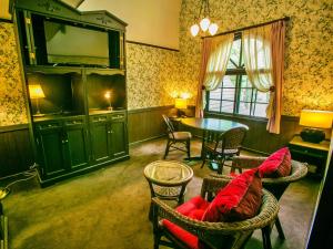 a living room with a tv and a table and chairs at Restaurant & Hotel Traumerei in Hakuba
