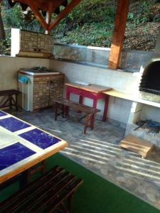 un patio con fogones, mesa y bancos en Casa Puiu, en Slănic-Moldova