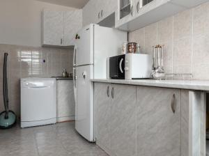 Una cocina con un frigorífico blanco y un lavavajillas. en Apartmani BA, en Sarajevo