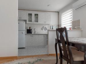 Una cocina con una mesa y una silla en una habitación. en Apartmani BA, en Sarajevo 17 fotos más