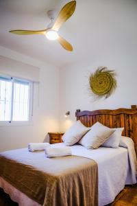 Casas Dibaca by El Palmar في إل بلمار: غرفة نوم مع سرير ومروحة سقف
