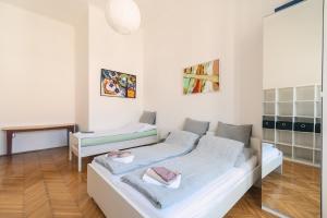 Cette chambre blanche comprend un lit et un bureau. dans l'établissement Sunny, Airy, Artsy & Authentic Loft with Balcony, à Budapest