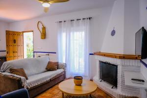 Casas Dibaca by El Palmar في إل بلمار: غرفة معيشة مع أريكة ومدفأة