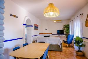 uma sala de jantar com uma mesa e cadeiras azuis em Casas Dibaca by El Palmar em El Palmar