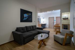 ein Wohnzimmer mit Sofa und Tisch in der Unterkunft Maxblue 2 in Piräus