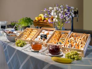 einen Tisch mit Schachteln mit Gebäck und Obst in der Unterkunft Hotel Michael in Prag