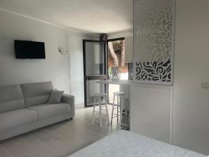 een woonkamer met een bank en een keuken met een raam bij Villa Nunziatella Badia in Trappeto
