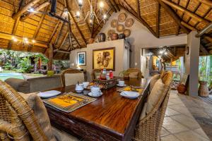ein Esszimmer mit einem Holztisch und Stühlen in der Unterkunft Mhlati Guest Cottages in Malelane
