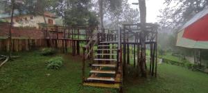 a spiral staircase in a yard with a house at LUSHOTO EXECUTIVE LODGE in Lushoto