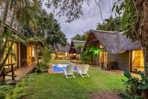 a villa with a pool and a yard at Mhlati Guest Cottages in Malelane