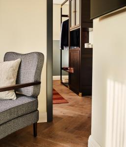 a living room with a chair and a closet at The Hoxton, Charlottenburg in Berlin