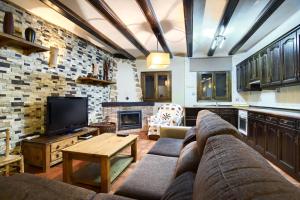 a living room with a couch and a fireplace at Casa Rural El Olmo in Gúdar