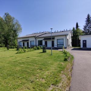 a white house with a grass yard in front of it at Villa Veromäki in Vantaa