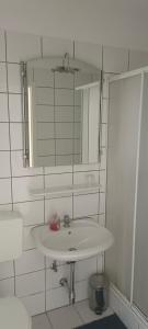 Gasthaus Schwarzer Adler في Altenberg: حمام أبيض مع حوض ومرآة