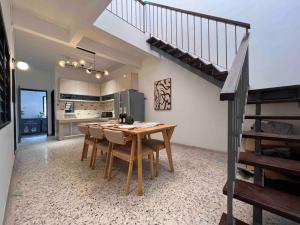 a kitchen and dining room with a table and a staircase at Petaling Jaya SS2 Seapark Landed House, 4BedRoom, for 12 Pax with Netflix in Petaling Jaya