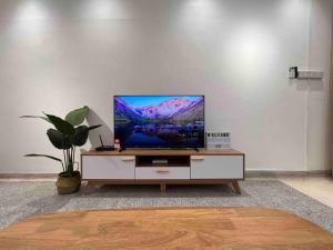 a tv sitting on a cabinet in a living room at Petaling Jaya SS2 Seapark Landed House, 4BedRoom, for 12 Pax with Netflix in Petaling Jaya