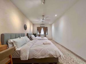 a bedroom with a large bed with white sheets at Petaling Jaya SS2 Seapark Landed House, 4BedRoom, for 12 Pax with Netflix in Petaling Jaya
