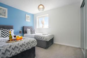 a living room with two beds and a couch at Detached House - Close to City Centre - Free Parking, Fast Wifi, Private Garden and Smart TV with Netflix by Yoko Property in Milton Keynes