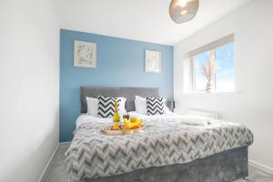 a bedroom with a bed with a tray of fruit on it at Detached House - Close to City Centre - Free Parking, Fast Wifi, Private Garden and Smart TV with Netflix by Yoko Property in Milton Keynes
