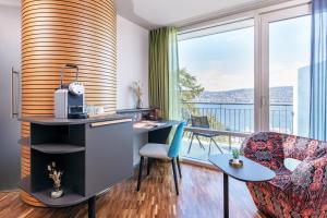 an office with a desk and chairs and a balcony at Sedartis Swiss Quality Hotel in Thalwil