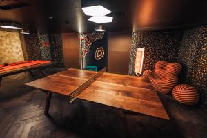 Amazing Rooms by FIVE في زيورخ: طاولة بينج بونغ في غرفة مع طاولة بلياردو