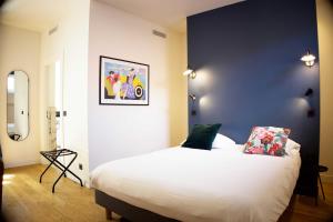a bedroom with a white bed and a blue wall at Boutique Hotel Nice Côte d'azur in Nice