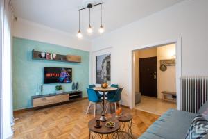 a living room with a table and a tv at Blue Ark Wanderlust in Athens