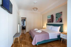 a bedroom with a large bed and a chair at Blue Ark Wanderlust in Athens