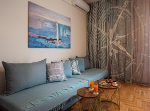 - un salon avec un canapé bleu et 2 tables dans l'établissement Blue Ark Wanderlust, à Athènes