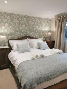 WiveliscombeにあるLuxury Cottage in Somersetのベッドルーム1室(ベッド1台、タオル2枚付)