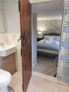 a bathroom with a bed and a sink and a toilet at Luxury Cottage in Somerset in Wiveliscombe