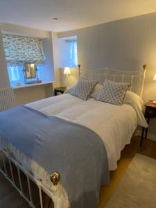 1 dormitorio con 1 cama blanca grande y 2 almohadas en Luxury Cottage in Somerset, en Wiveliscombe