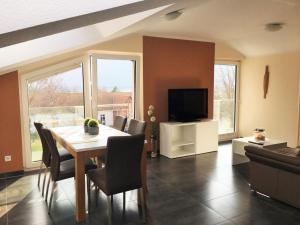 a dining room with a table and chairs and a television at Fewo 215 Erik in Rerik in Rerik