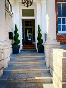 una puerta delantera de una casa blanca con escaleras en Chapter 1 Hotels en Weymouth