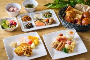 a table with three plates of food and a basket of food at Shinagawa Prince Hotel East Tower in Tokyo