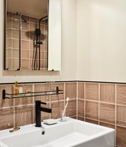 ein Bad mit einem Waschbecken und einem Spiegel in der Unterkunft The Hoxton, Charlottenburg in Berlin