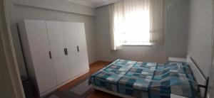 sypialnia z łóżkiem, szafką i oknem w obiekcie ev_3+1_ulg w mieście Antalya